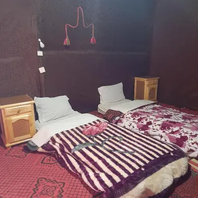 two beds sitting next to each other in a room at RestCamp ErgChebbi in Merzouga