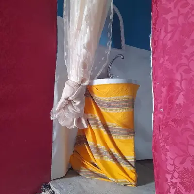 a large yellow bucket sitting next to a curtain at RestCamp ErgChebbi in Merzouga