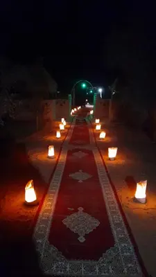 a long row of candles on the ground at night at RestCamp ErgChebbi in Merzouga