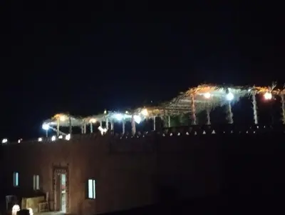 a building with lights on top of it at night at RestCamp ErgChebbi in Merzouga