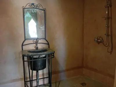 a bathroom with a sink and a mirror on a stand at RestCamp ErgChebbi in Merzouga