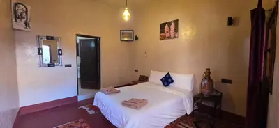 a bedroom with a white bed with towels on it at Chez Brahim vue panoramique in Aït Ben Haddou