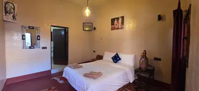 a bedroom with a white bed with towels on it at Chez Brahim vue panoramique in Aït Ben Haddou