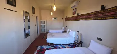 a room with three beds in a room at Chez Brahim vue panoramique in Aït Ben Haddou