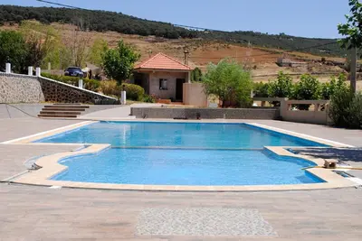 a large blue swimming pool in a yard at Tamanoucht in Ifrane
