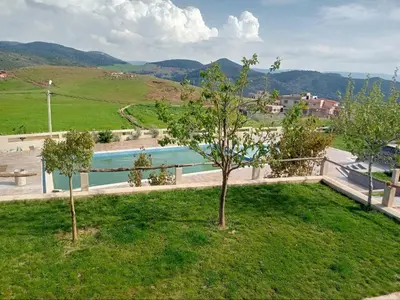 a garden with two trees and a swimming pool at Tamanoucht in Ifrane