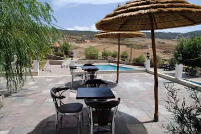 a patio with tables and chairs and an umbrella at Tamanoucht in Ifrane