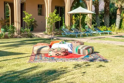 a blanket on the grass in front of a house at Dar Hnini in Zagora