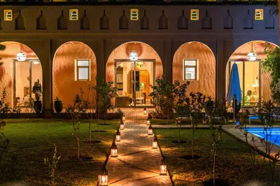 a courtyard with a pool and a building with lights at Dar Hnini in Zagora