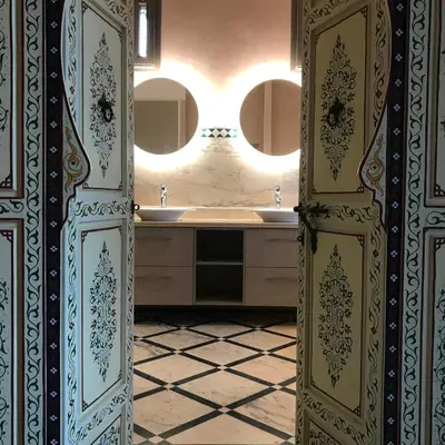 a bathroom with a sink and two mirrors at Dar Hnini in Zagora