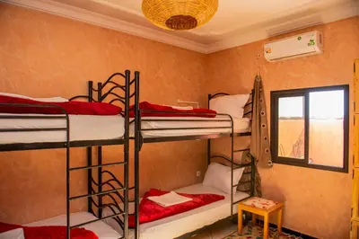 a room with four bunk beds and a window at Afgo Hostel in Ouarzazate