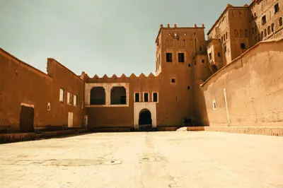 an empty courtyard of a building with a castle at Afgo Hostel in Ouarzazate
