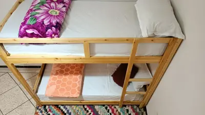 a bunk bed in a room next to a wall at Afgo Hostel in Ouarzazate