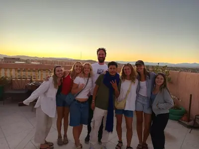 a group of people posing for a picture on a balcony at Afgo Hostel in Ouarzazate
