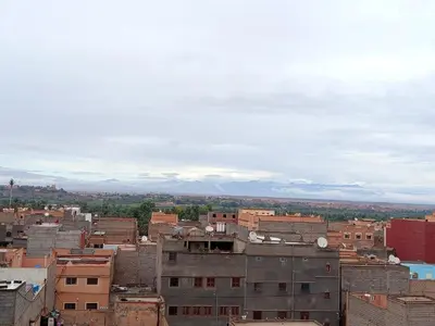 a city with buildings and mountains in the background at Afgo Hostel in Ouarzazate