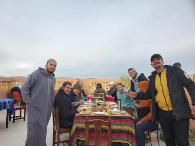 a group of people sitting around a table at Afgo Hostel in Ouarzazate