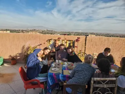 a group of people sitting around a table at Hostel Afgo Rooftop in Ouarzazate