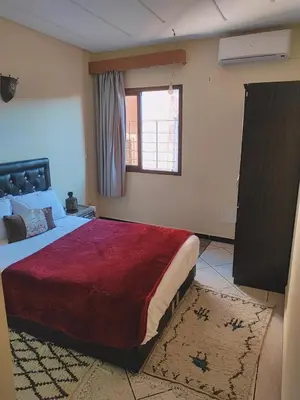 a bedroom with a large bed and a window at Hostel Afgo Rooftop in Ouarzazate