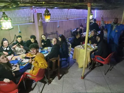 a group of people sitting at tables in a restaurant at Hostel Afgo Rooftop in Ouarzazate