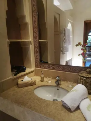 a bathroom with a sink with a large mirror at Domaine Casa Cecilia in Marrakech