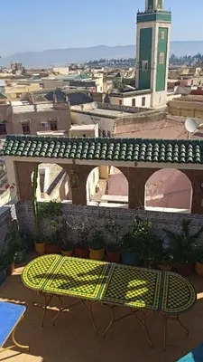a balcony with a bench and a view of a city at Riad Malak in Meknès