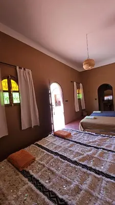 a bedroom with a bed and an open door at Dar M'hamid in Mhamid