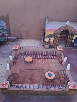 a room with a table and a painting on the wall at Dar M'hamid in Mhamid