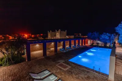 an image of a swimming pool at night at Dar El Janoub in Merzouga