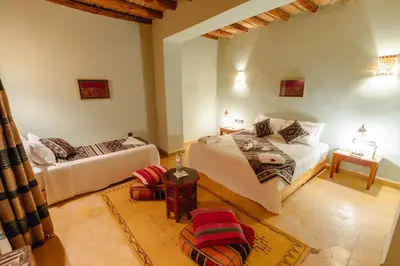 a living room with two beds and a couch at Dar El Janoub in Merzouga