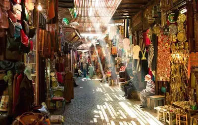 a street in a market with people sitting in the aisle at Charming Riad Ouliya in Fs in Fès