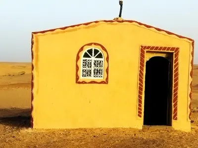 a small yellow building with a window in the desert at les dunes D'or in Tagounite