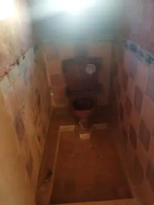 a bathroom with a toilet in a tiled room at les dunes D'or in Tagounite