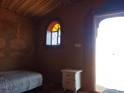 a bedroom with a bed and a stained glass window at les dunes D'or in Tagounite
