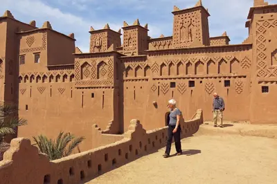 two people standing in front of a building at kasbah Dar Bahnini in Skoura