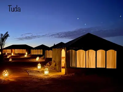 a group of tents with lights at night at Tuda Luxury Camp in Merzouga