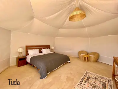 a bedroom with a bed in a tent at Tuda Luxury Camp in Merzouga