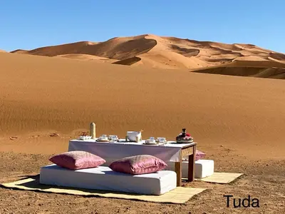 a table in the middle of the desert at Tuda Luxury Camp in Merzouga