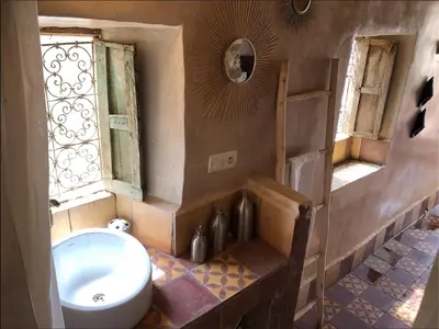 a bathroom with a toilet and a sink and a window at Maison d'hôte ''J'' in Agdz