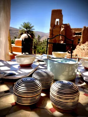a table with plates and bowls on top of it at Maison d'hôte ''J'' in Agdz