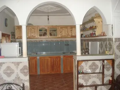 a kitchen with wooden cabinets and blue tile at Gîte Imarin in Agouti