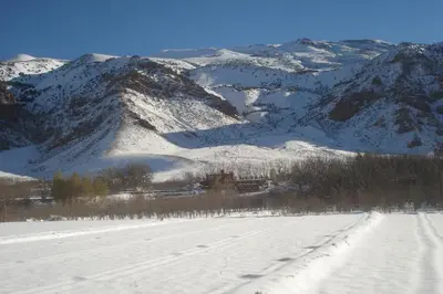 a snow covered mountain range with a train in the distance at Gîte Imarin in Agouti