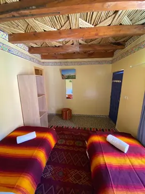 two beds in a room with a wooden ceiling at Gîte Imarin in Agouti