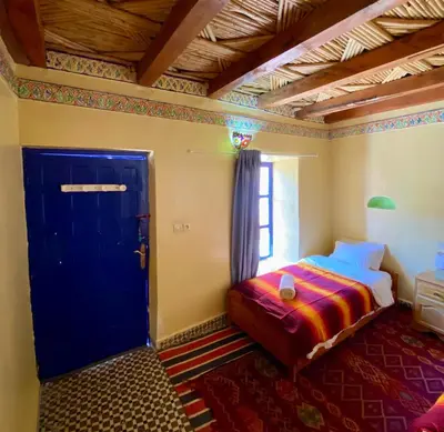 a bedroom with a bed and a blue door at Gîte Imarin in Agouti