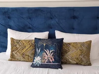 a group of pillows on a bed with a blue headboard at Groupe appart-La casa de Wael in Ifrane