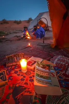 a candle and people sitting in a tent with a fire at Exclusive 