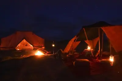 two tents are lit up at night at Exclusive 