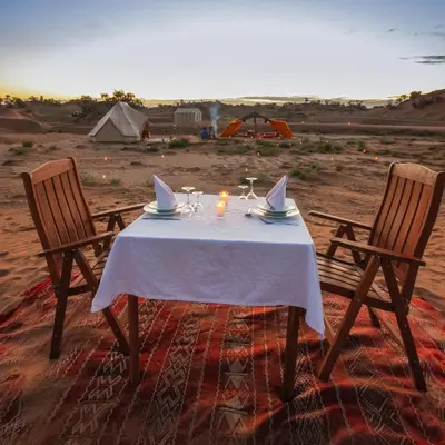 a table with a candle and two chairs in the desert at Exclusive 