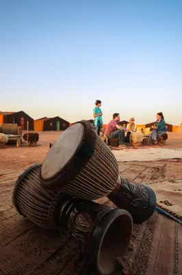 a toilet sitting on the ground with people in the background at Rêve du Sahara - Dar Azawad Desert Camp in Mhamid