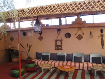 a patio with a couch and a table and chairs at Kasbah ben Ali in Kalaat MGouna