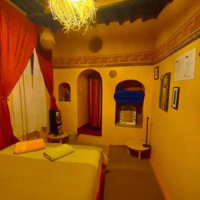 a bedroom with two beds and a chandelier at Kasbah ben Ali in Kalaat MGouna